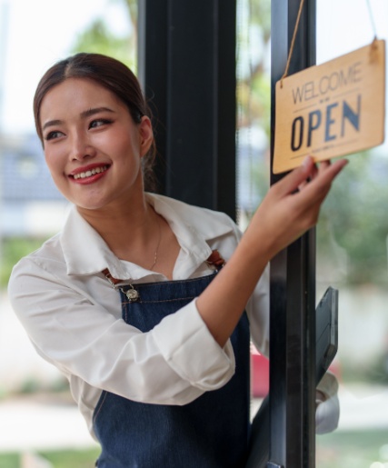 Small business owner flipping a sign from closed to open.